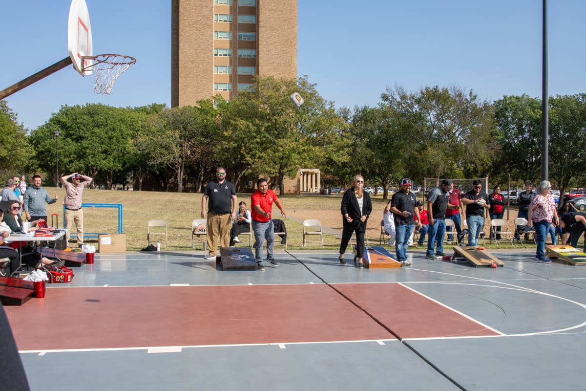 Tournament player releasing a cornhole bag toward a regulation board at the SECC cornhole competition