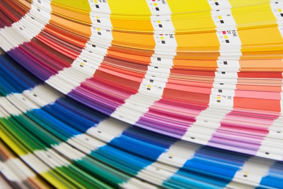 A fanned printing color swatch book used to match artwork colors before a cornhole board graphic is applied