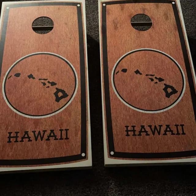 Pair of warm wood cornhole boards printed with a circular Hawaiian islands map and the word Hawaii
